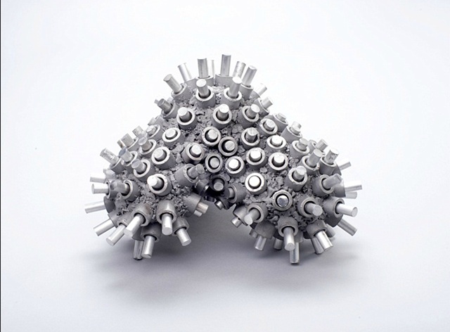 A metal sculpture with small appendages which give it the appearance of some kind of abstract sea coral