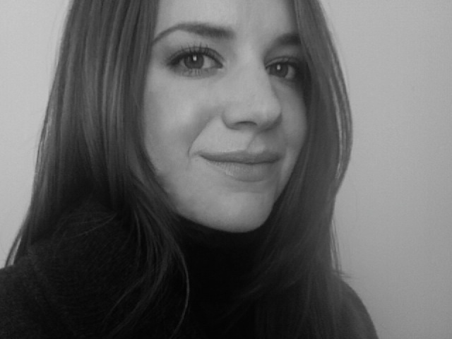 A woman in her twenties with shoulder-length brunette hair wearing a black shirt