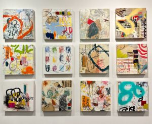 A group of 12 small canvases with pieces of printed newspaper mixed with various painting strokes, spray paint lines and red charcoal patterns