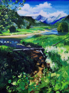 Landscape of a river running through mountain foothills on a clear day with foliage in full bloom